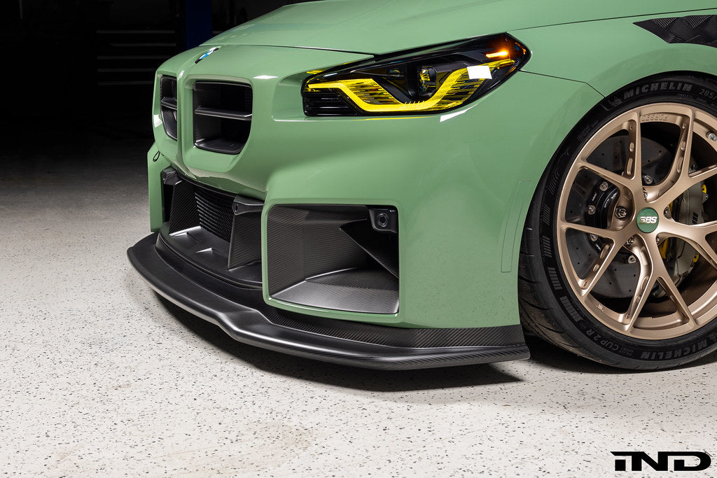 Alpha N G87 M2 Carbon Corse front splitter installed, matte clear exterior automotive part for enhanced aerodynamics.