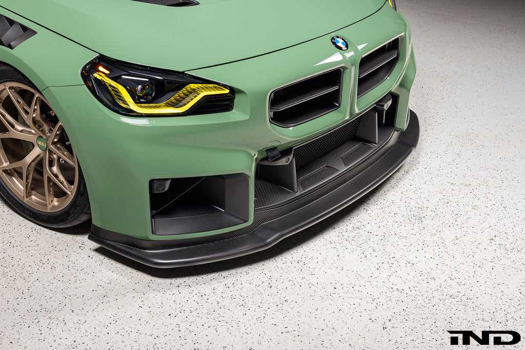 Alpha N G87 M2 Carbon Corse front splitter installed on vehicle, matte clear finish, exterior car enhancement, sporty aerodynamic accessory
