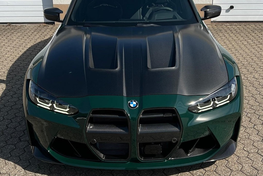 Alpha N G8X M3 M4 carbon front corner splitter set installed on vehicle, enhancing exterior performance and sporty look.