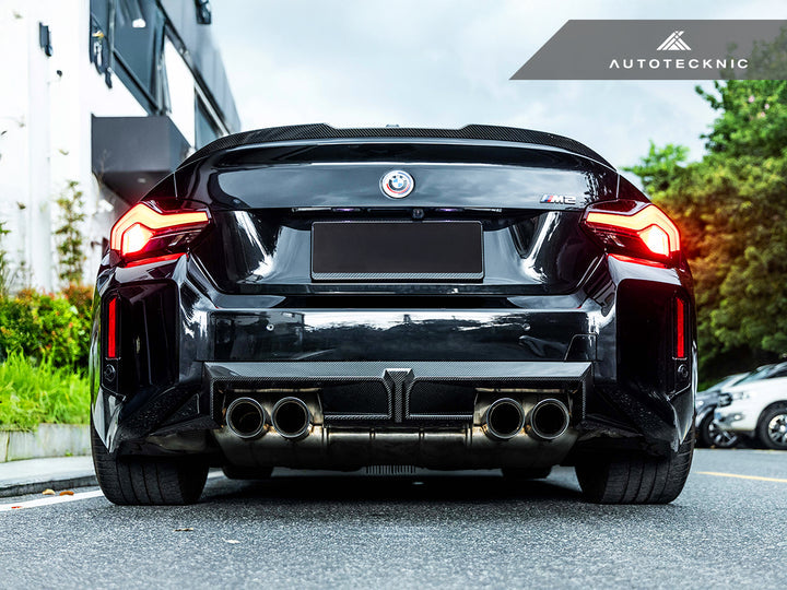AutoTecknic BMW G87 M2 dry carbon rear diffuser installed on the vehicle's exterior, showcasing a sleek, high-performance design.