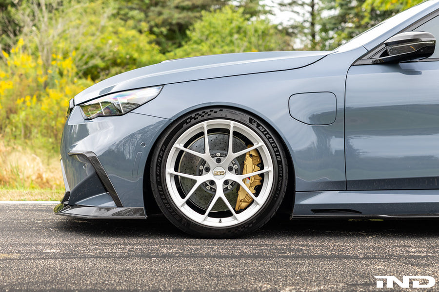 Close-up of a Ceramica BBS FI-R 21-inch forged wheel on a BMW G99 M5 Touring, showing the spoke face and gold brake caliper.