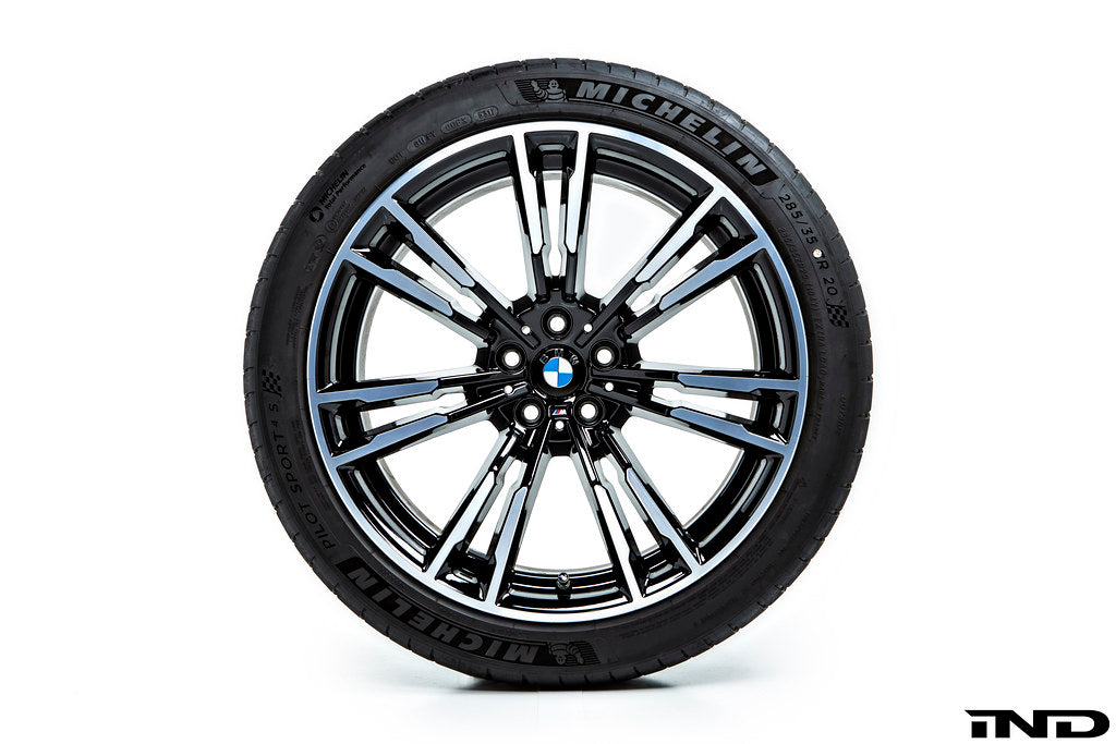 IND Gloss Black Wheel Center Cap Set for BMW, 56mm, installed on wheel with tire, on white background.