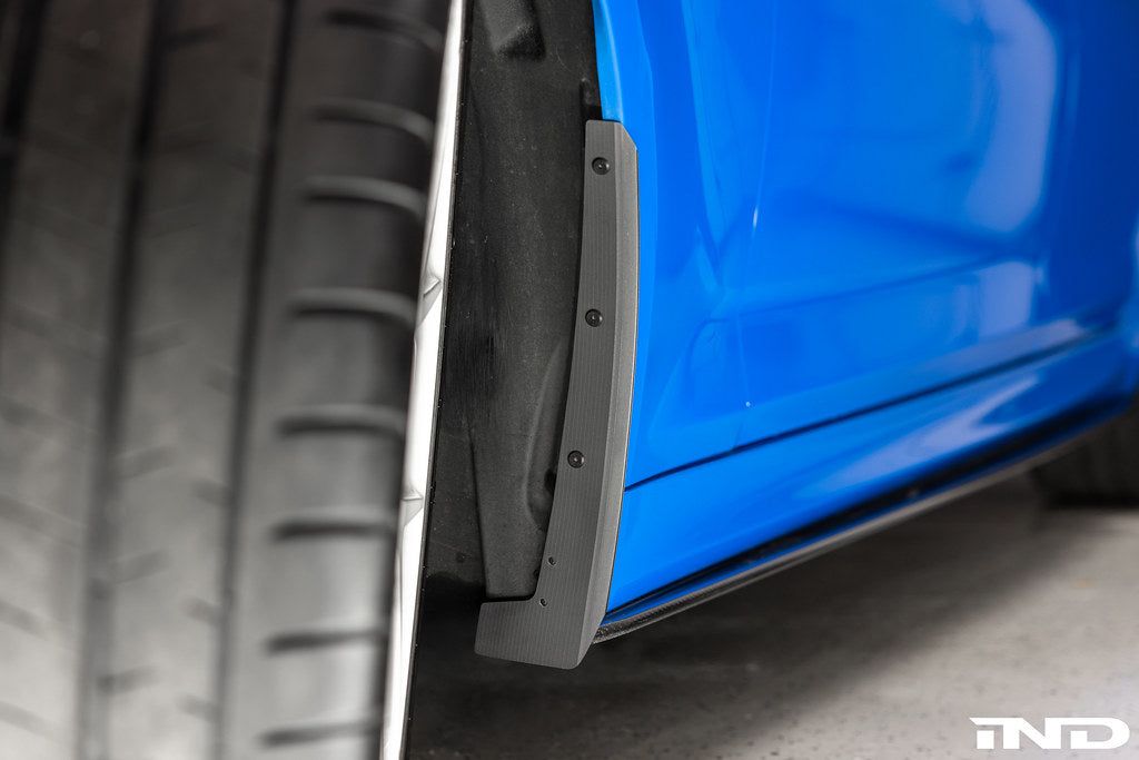 BMW F90 M5 Megachip splash guard set installed, blue exterior protection guards on the car's wheel arches.