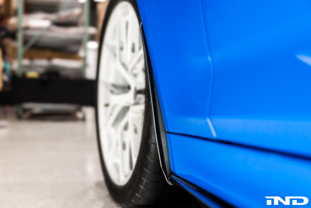 Megachip F90 M5 splash guard set installed on a BMW F90 M5, showing blue exterior splash guards on the car's wheel arches.