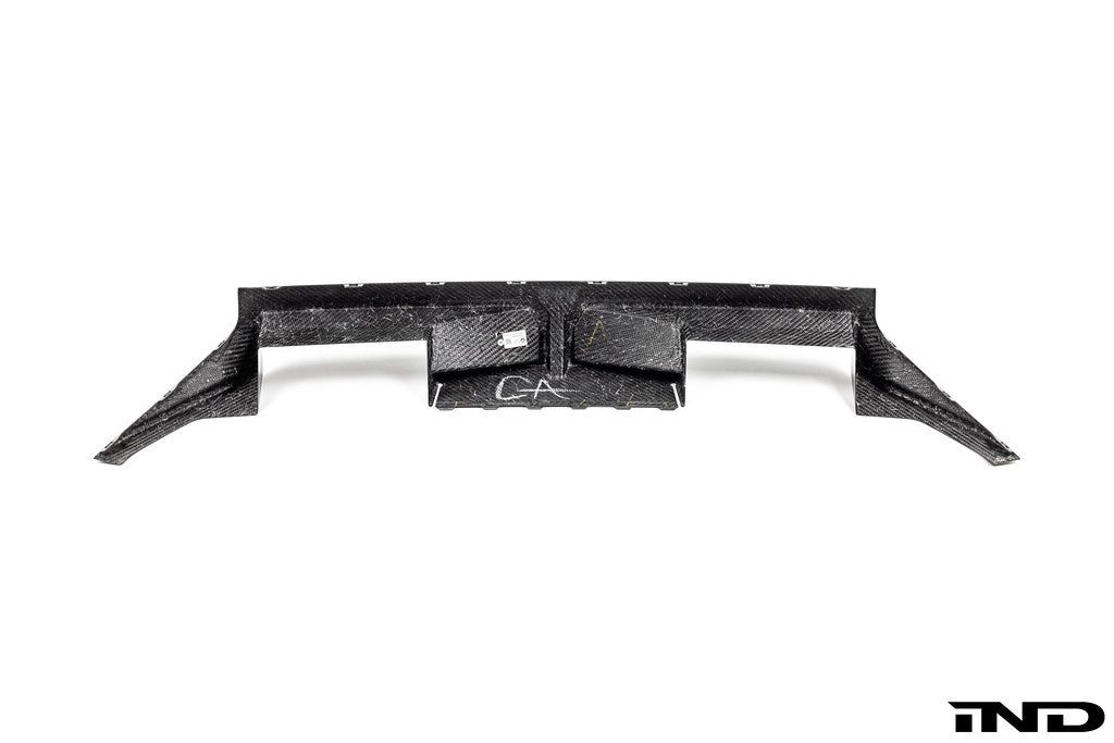 BMW G87 M2 CS carbon rear diffuser, exterior car part with aerodynamic design and black carbon fiber finish.