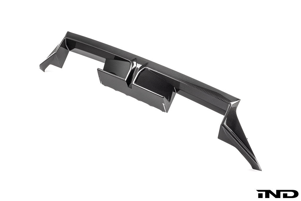 BMW G87 M2 CS exterior carbon rear diffuser showing aerodynamic design and textured carbon fiber finish.