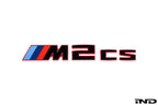 BMW G87 M2 CS trunk emblem in gloss black with red border on a white background, exterior car badge detail.