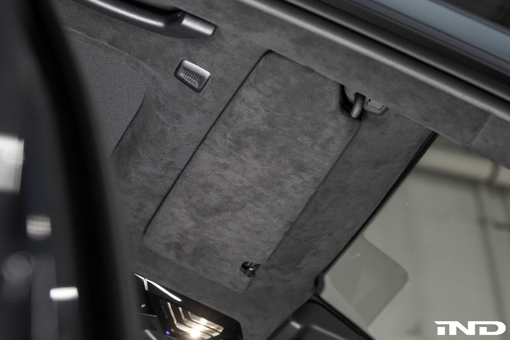 Installed BMW G90 G99 M5 Alcantara European sun visor set in vehicle interior close up