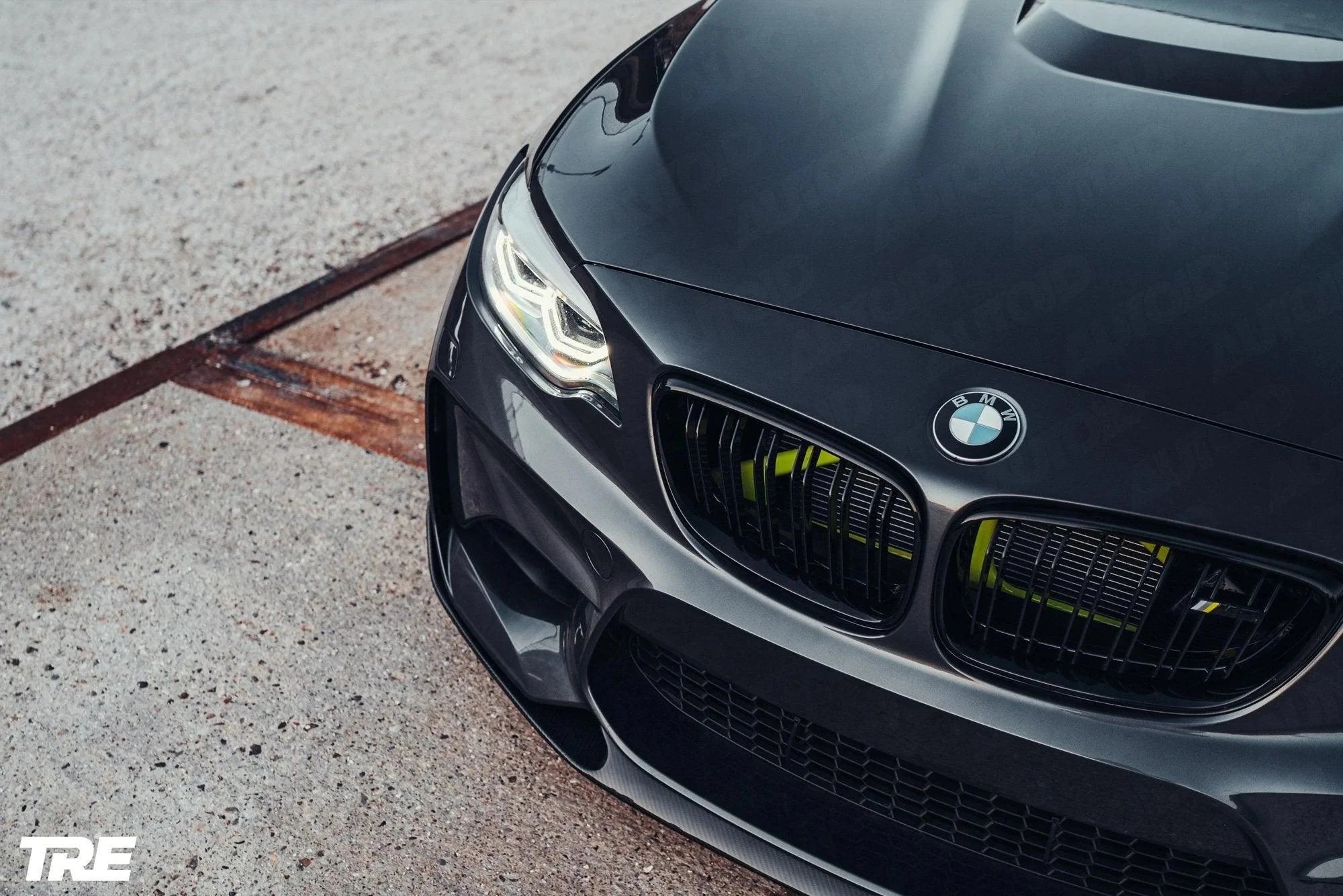 TREVORA BMW F87 M2 OG pre-preg carbon fiber front splitter installed on 2015-2018 BMW M2, enhancing aerodynamics and sporty appearance.