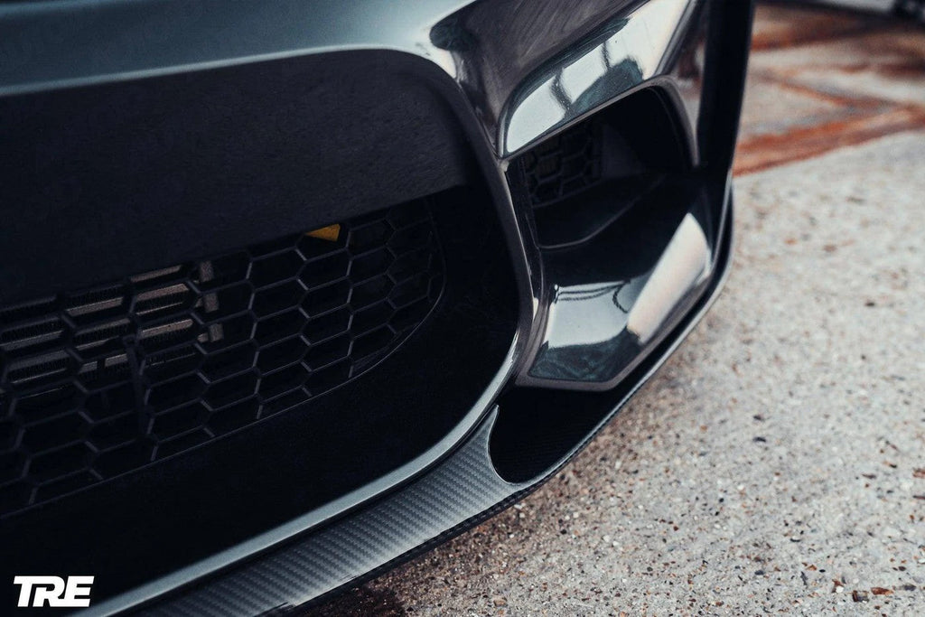 TREVORA BMW F87 M2 OG pre-preg carbon front splitter installed on the exterior of a 2015-2018 BMW M2.
