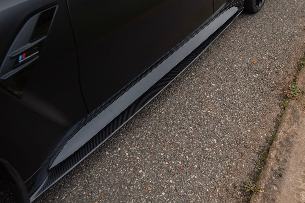 BMW M3 G80 side skirts, TREVORA G80 M3 Pre-Preg Carbon Fiber PR-1 exterior parts on a black car.