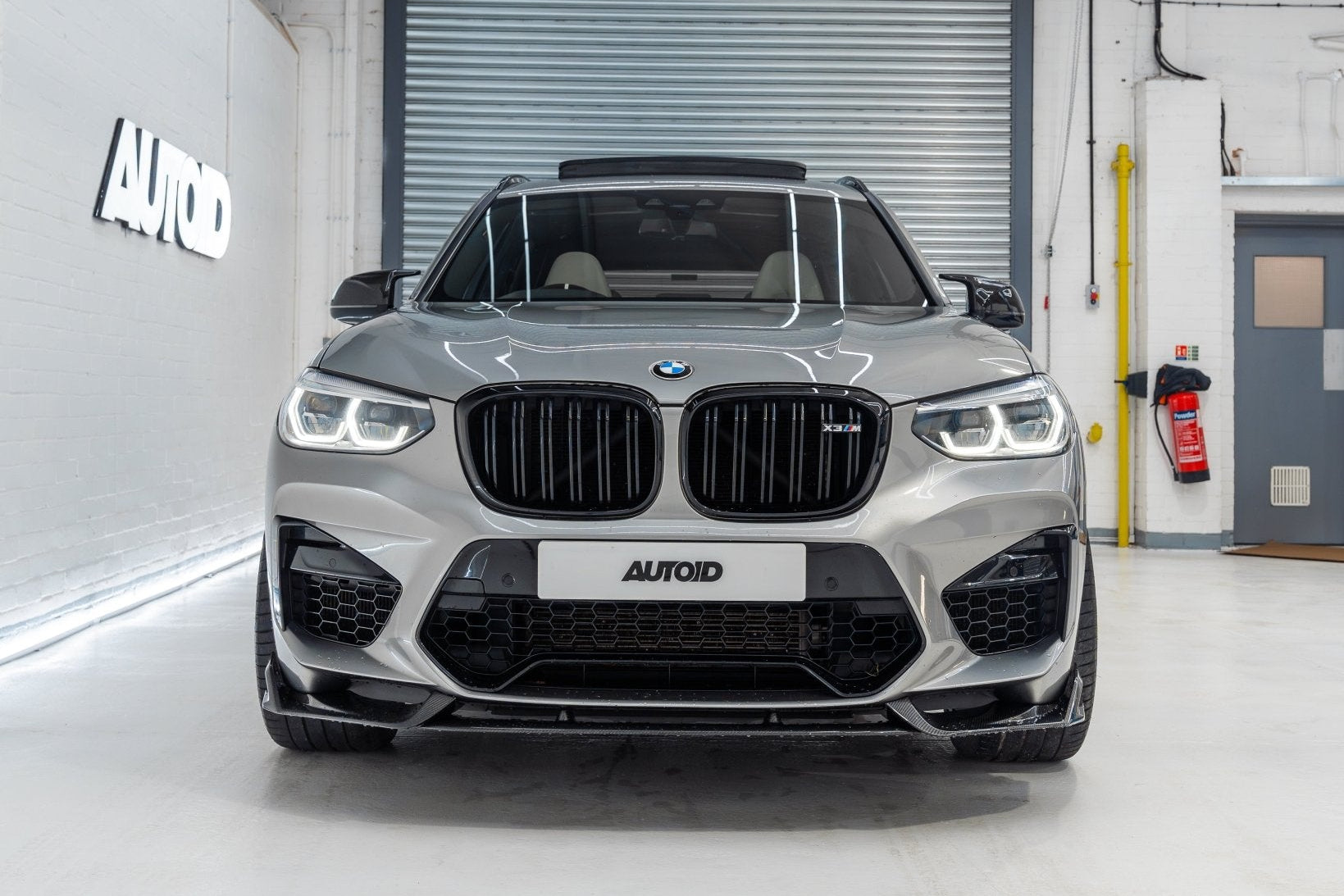 TREVORA BMW F97 X3M and F98 X4M Pre-LCI carbon fiber front splitter installed on the exterior of the vehicle.