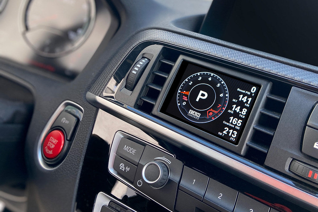 CANchecked F8X/F3X/F22 Multi-Function Display installed inside a BMW F87 M2 interior, showing the 2.8-inch Gen2 LCD screen.