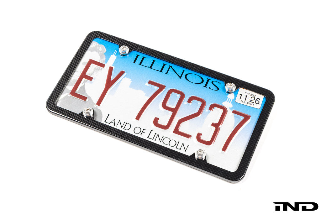 Downstar BMW License Plate Dress Up Hardware installed on a license plate with a carbon fiber license plate frame, featuring stainless steel fasteners and billet aluminum beauty washers, shown on a white background.