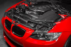 Eventuri gloss carbon fiber duct set installed in the engine bay of a red BMW E92 M3 Coupe