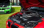 Eventuri BMW E92 M3 matte carbon duct set installed on red coupe, showcasing high-performance aerodynamics and precision craftsmanship.