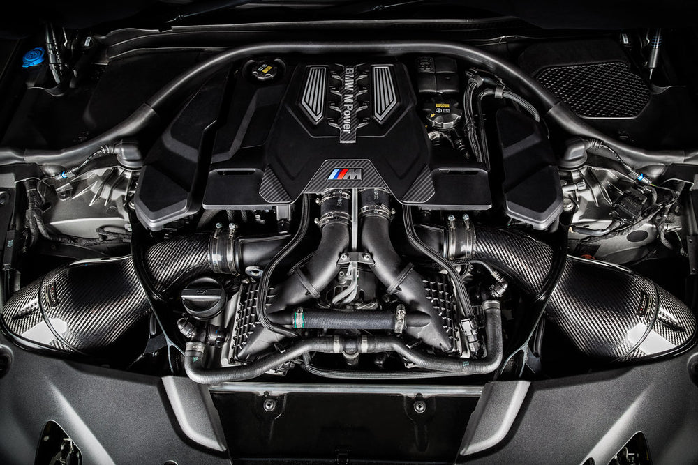 Eventuri Black Carbon Intake System installed in a BMW F92 M8 engine bay featuring pre-preg carbon fiber intake housings and intake scoops.