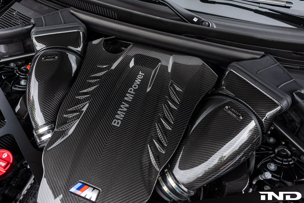 Eventuri black carbon intake system installed in BMW F95 X5M with S63 engine, showing engine bay and performance components.