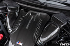 Eventuri black carbon intake system installed in BMW F95 X5M with S63 engine, showing engine bay and performance components.