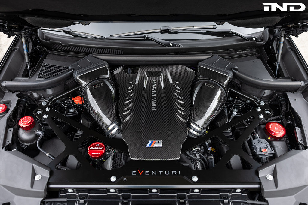 Eventuri black carbon intake system installed in BMW F95 X5M with S63 engine, showing performance air intake in engine bay.