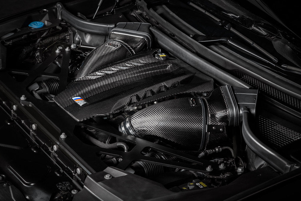 Eventuri black carbon intake system installed in engine bay of BMW F95 X5M, X6M, G09 XM, M60i performance vehicle.