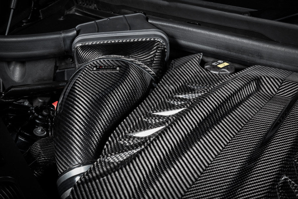 Eventuri black carbon intake system installed in BMW F95 X5M G09 XM G06 M60i engine bay, showcasing performance upgrade.