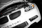 Eventuri black carbon intake system installed in engine bay of BMW E9X M3 (S65) performance vehicle, showcasing glossy finish.