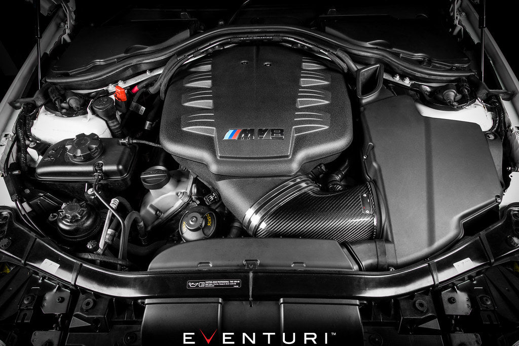 Eventuri black carbon intake system installed in BMW E9X M3 S65 engine bay, showcasing high-performance automotive components.