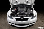 Overhead installed view of Eventuri E9X M3 S65 matte black carbon airbox lid with optional intake and plenum in engine bay
