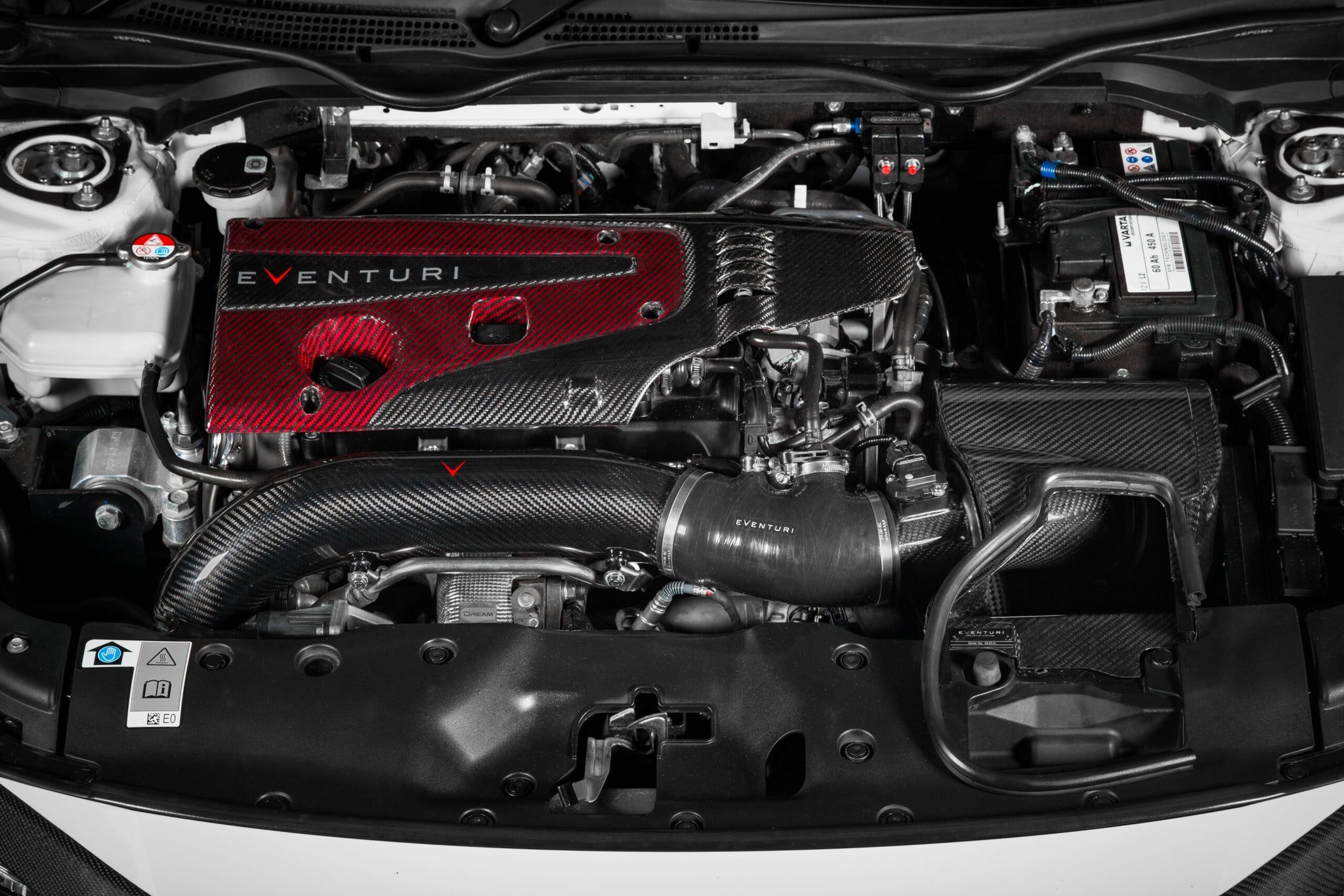 Close-up overhead installed view of Eventuri FK8 Type R V3 carbon turbo inlet tube showing carbon fiber intake in the engine bay with optional engine cover