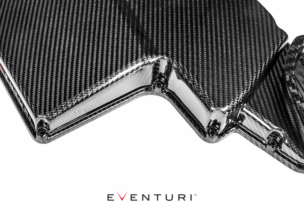 Eventuri black gloss carbon airbox lid for BMW E9X M3 S65 engine, close-up showing sleek, high-quality performance car part.