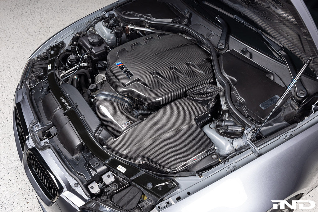 Eventuri black gloss carbon airbox lid for BMW E9X M3 S65 engine bay, showcasing high-performance engine bay upgrade.