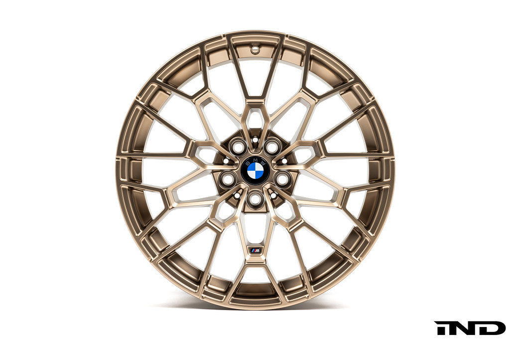 IND Gloss Black Wheel Center Cap Set for BMW, 56mm size, installed on gold wheels with a white background.