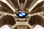 IND Gloss Black Wheel Center Cap Set for BMW, 56mm Next Dark design, installed on gold wheels with white background.