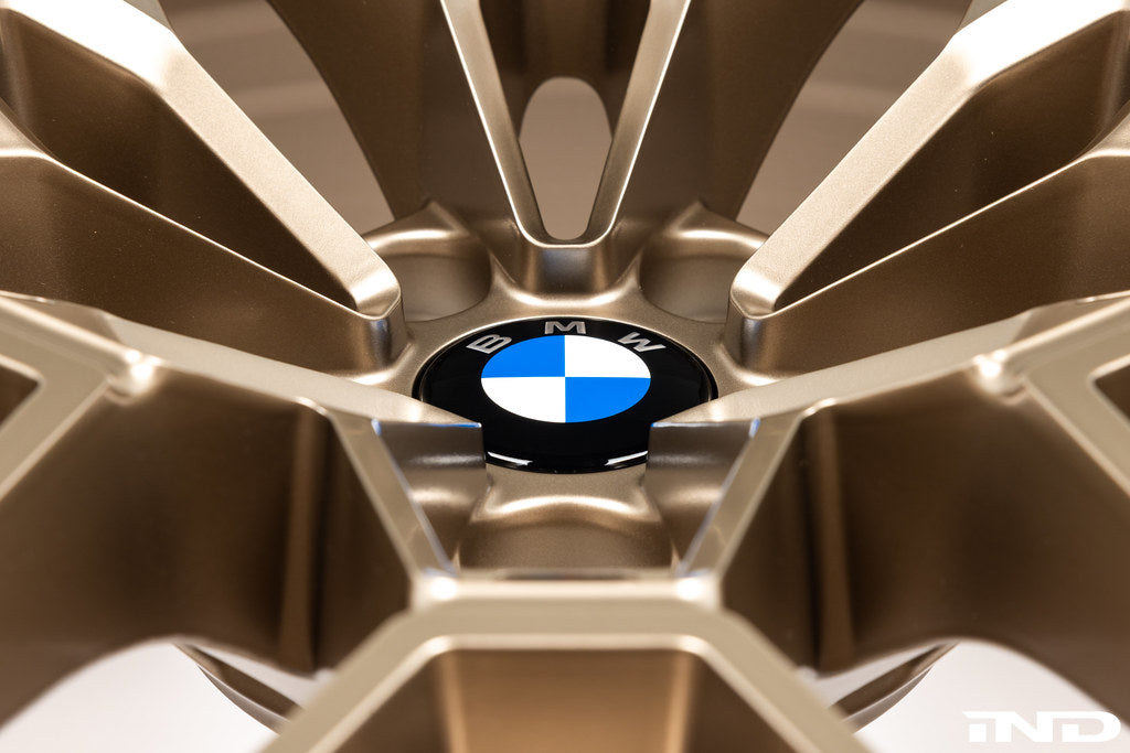 IND Gloss Black Wheel Center Cap Set for BMW, 56mm Next Dark design, installed on gold wheels with white background.