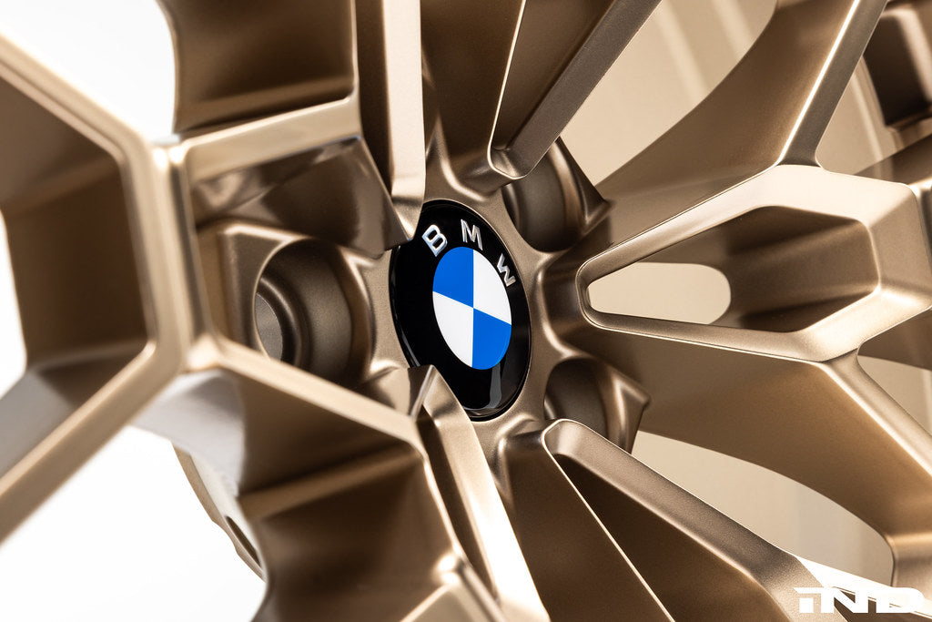 IND gloss black BMW 56mm wheel center cap set Next Dark design installed on BMW 827M gold wheels with white background