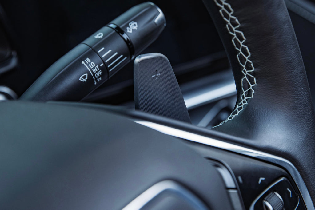 JQ Werks MadTrace C8 Corvette interior magnetic shift paddle set installed, showing close-up of sleek black paddle design.