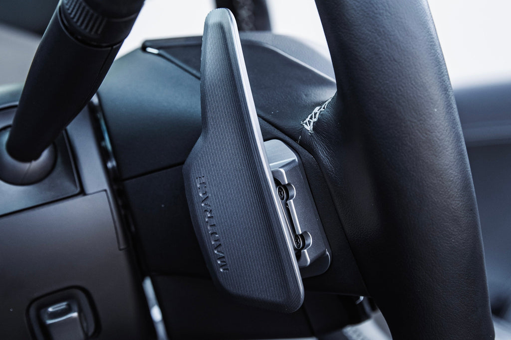 JQ Werks MadTrace C8 Corvette magnetic shift paddle set installed inside a car, showcasing sleek black design and interior placement.