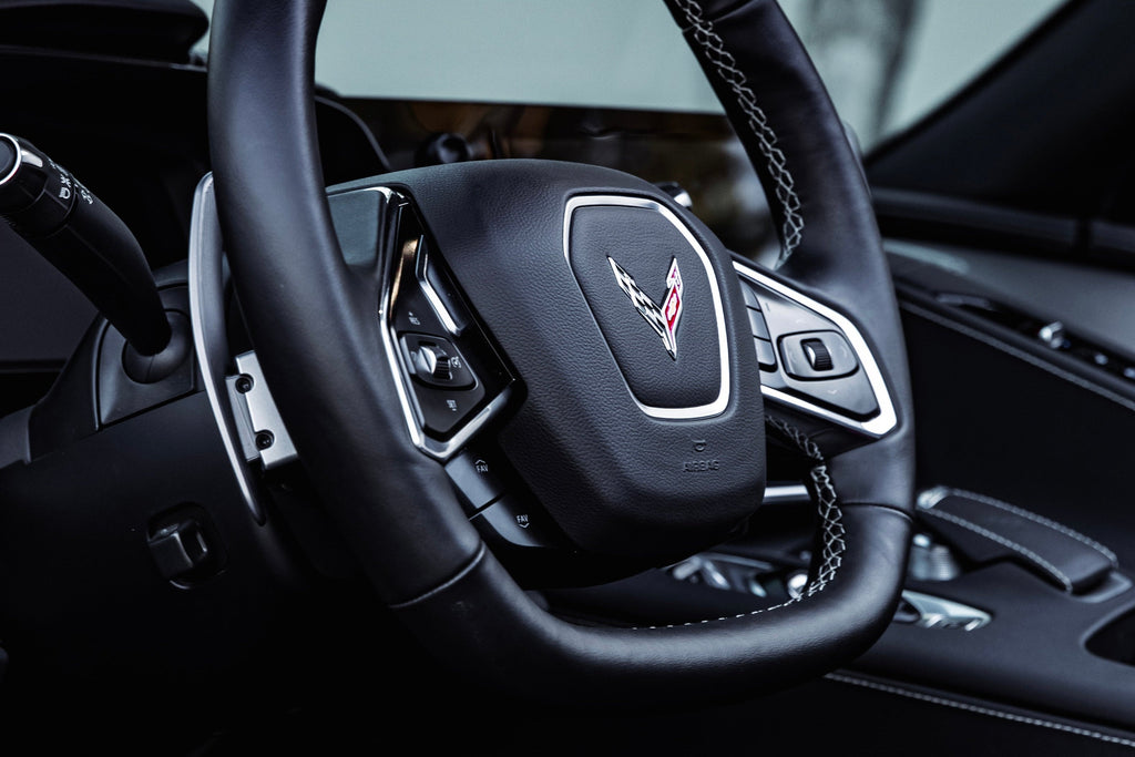 JQ Werks MadTrace C8 Corvette interior magnetic shift paddles installed in a car's steering wheel.