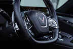 JQ Werks MadTrace C8 Corvette interior magnetic shift paddles installed in a car's steering wheel.