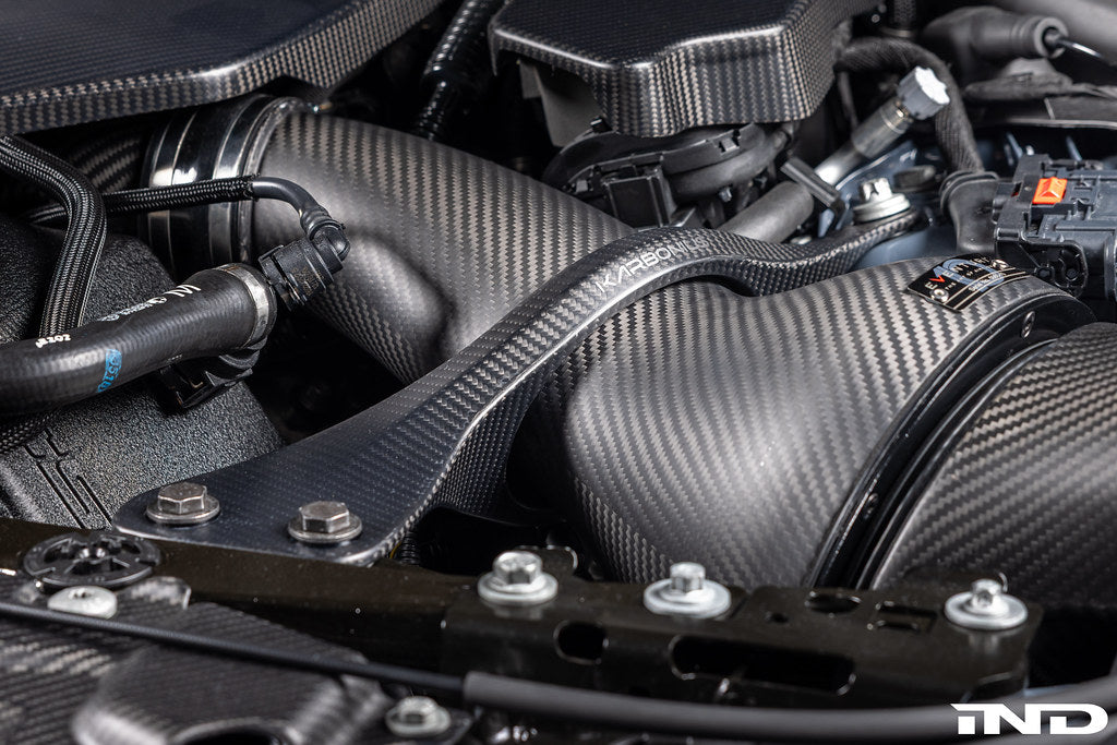 Karbonius G90 G99 M5 carbon fiber suspension strut brace set installed in a vehicle, showcasing lightweight, high-performance support.