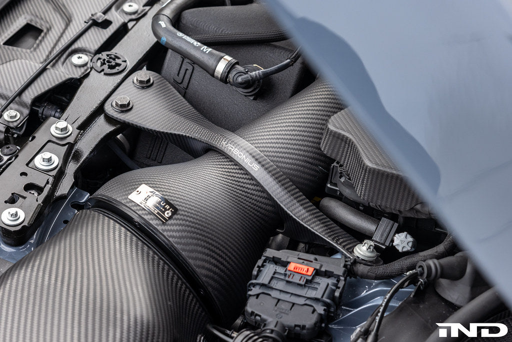 Karbonius G90 G99 M5 carbon fiber suspension strut brace set installed on a vehicle, showcasing lightweight, high-performance automotive parts.