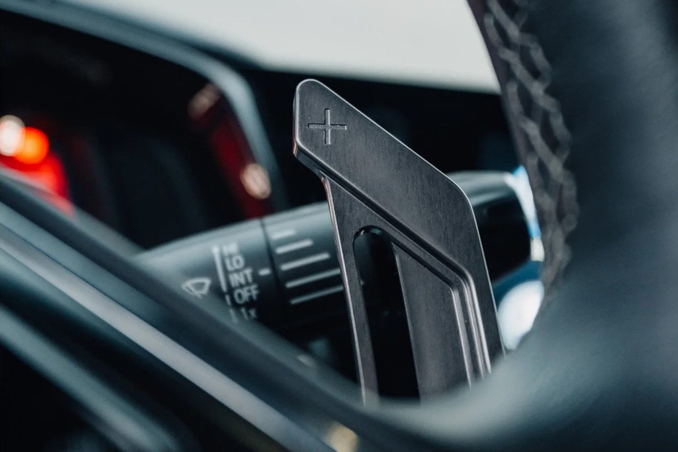 Close-up of MAED C8 Corvette billet magnetic shift paddle set installed inside the vehicle interior.