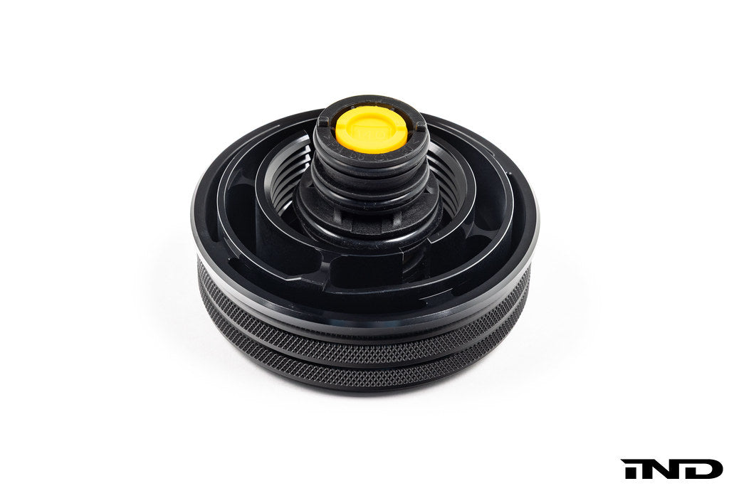 MMX Performance BMW billet coolant expansion cap in black anodized finish, designed for high-performance cooling systems.