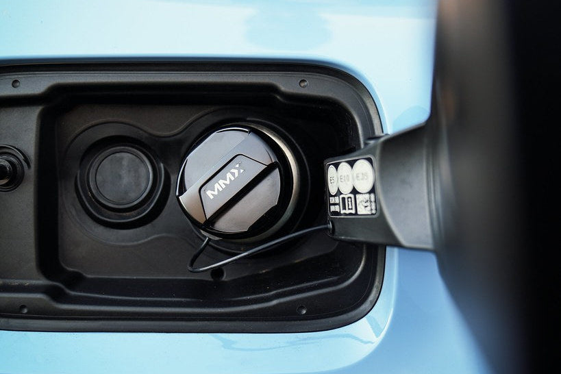 MMX Performance billet fuel cap installed on a BMW with the fuel door open, showcasing a sleek, durable exterior design.