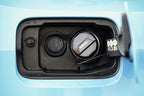 MMX Performance billet fuel cap installed on BMW, exterior view with open fuel door, showcasing polished metal design.