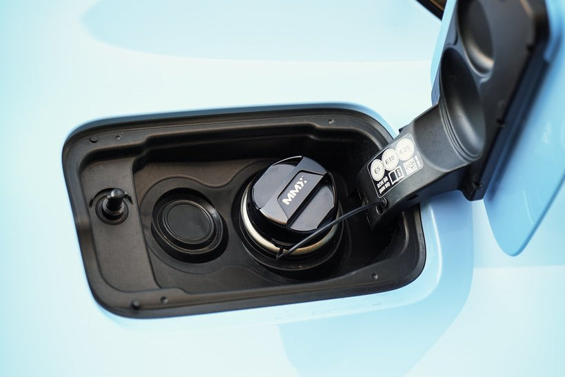 MMX Performance billet fuel cap installed on BMW with open fuel door, showcasing durable exterior design and high-quality craftsmanship.