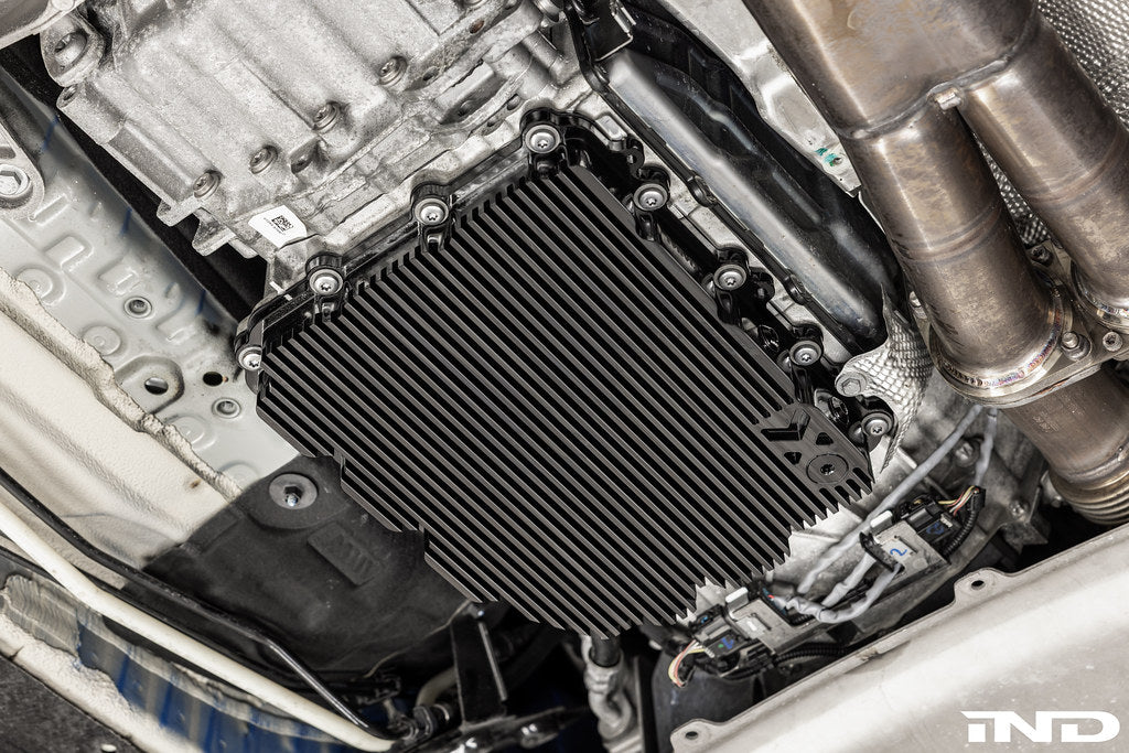 Black anodized MMX Performance aluminum BMW DCT oil pan installed on a vehicle, showcasing durable, high-performance automotive parts.