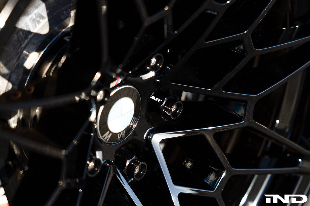 MMX Performance BMW wheel stud kit with M14x1.25 conical seat installed on a car wheel for secure mounting and performance.