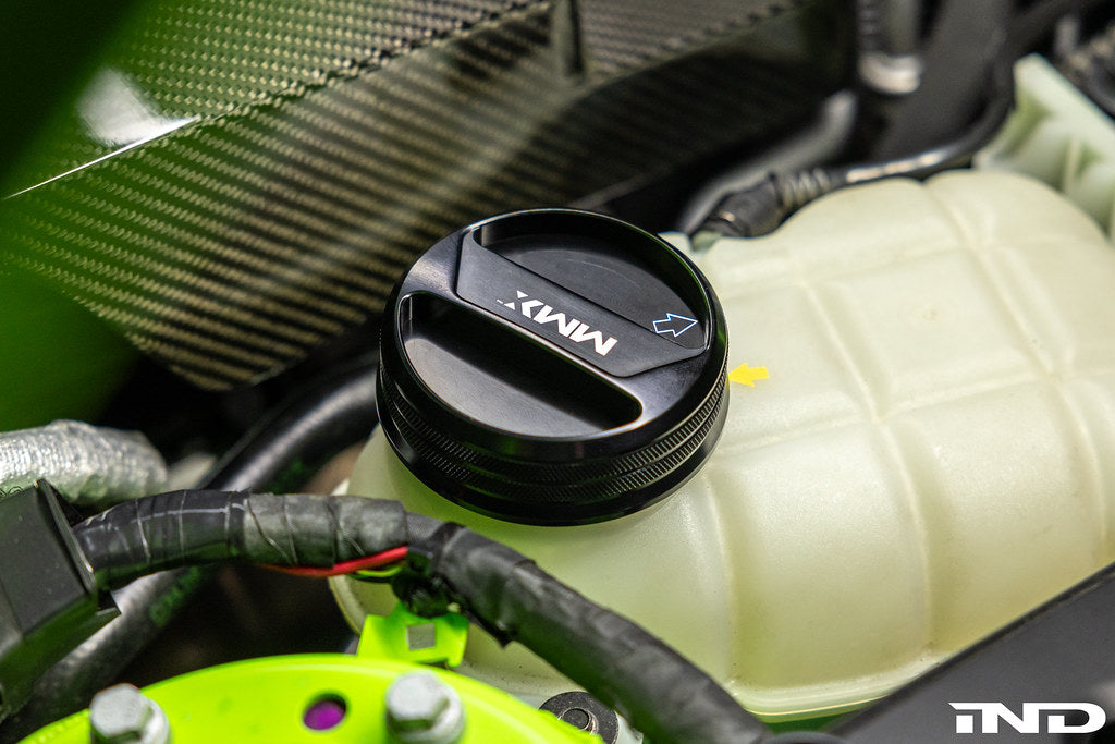 MMX Performance BMW billet coolant expansion cap installed on engine, showcasing a sleek, durable performance automotive accessory.